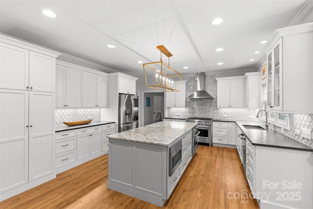 9513 Tresanton Dr, Charlotte, NC 28210 - kitchen with wall chimney range hood, stainless steel appliances, a sink, decorative backsplash, and a center island