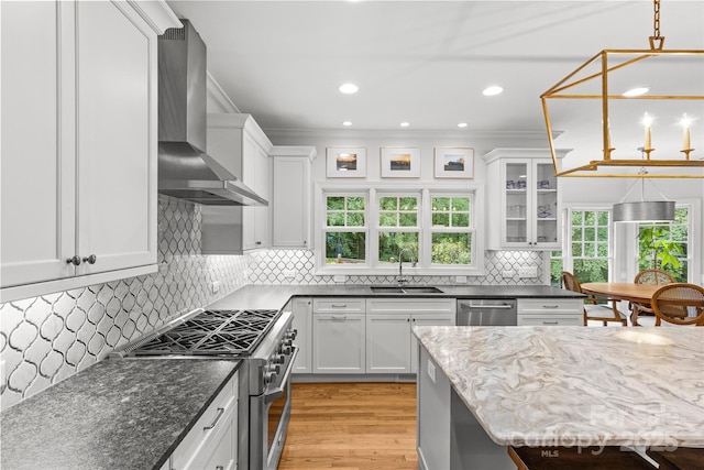 9513 Tresanton Dr, Charlotte, NC 28210 - kitchen featuring wall chimney range hood, appliances with stainless steel finishes, a sink, white cabinetry, and crown molding