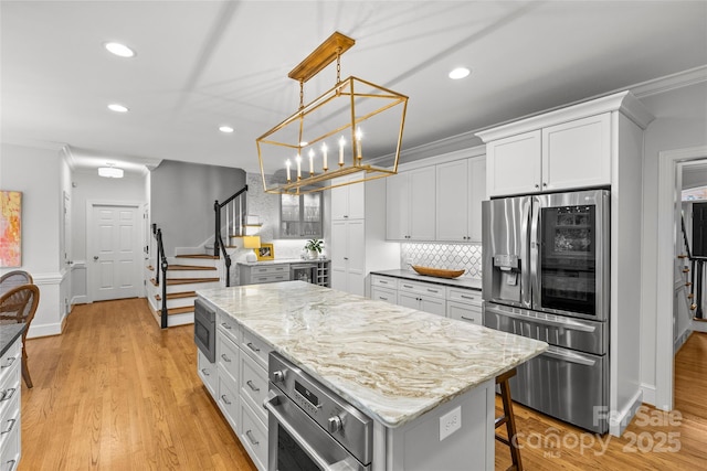 9513 Tresanton Dr, Charlotte, NC 28210 - kitchen with appliances with stainless steel finishes, recessed lighting, a center island, backsplash, and light wood-style floors