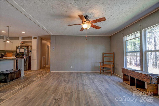 living area featuring visible vents, wood finished floors, recessed lighting, a textured ceiling, and a ceiling fan