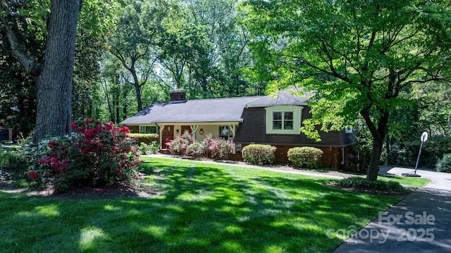 split level home featuring a chimney and a front yard