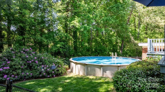 outdoor pool featuring a yard