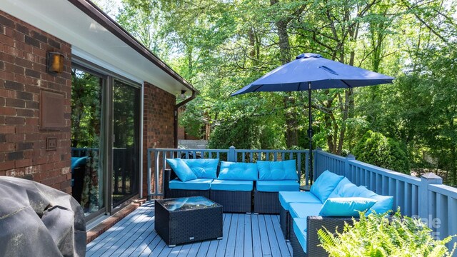 wooden terrace with an outdoor hangout area and grilling area