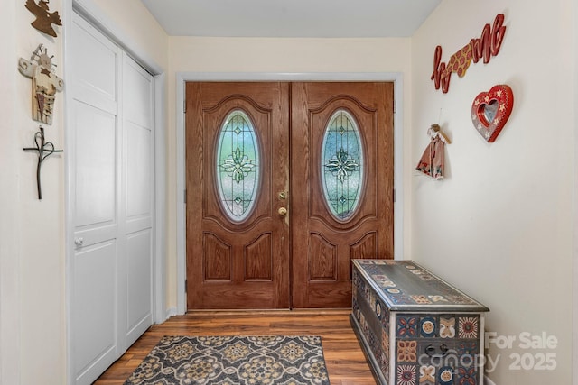 entryway with baseboards and wood finished floors