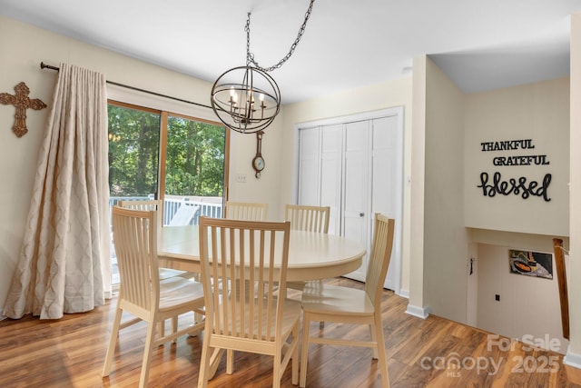 dining area featuring wood finished floors and a chandelier