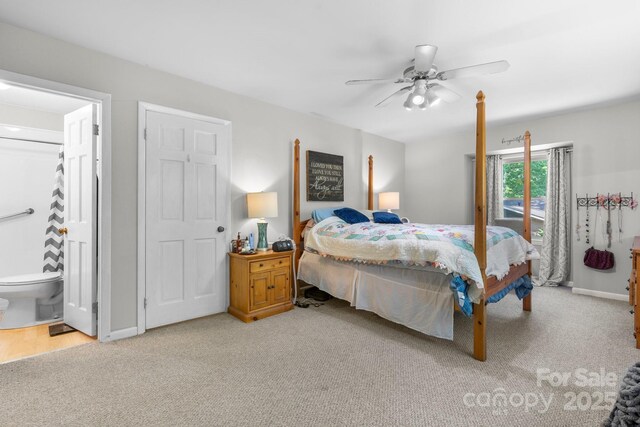 bedroom with baseboards, a ceiling fan, ensuite bath, and light carpet