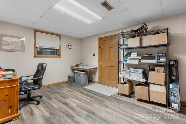 home office featuring a paneled ceiling, baseboards, visible vents, and wood finished floors