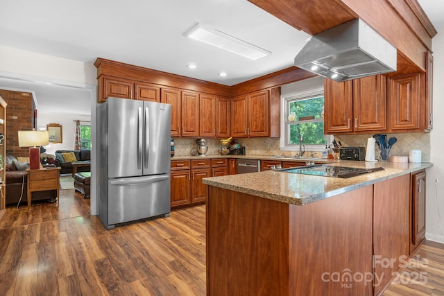 701 5th Ave NE, Conover, NC 28613 - kitchen with appliances with stainless steel finishes, range hood, a peninsula, wood finished floors, and brown cabinetry