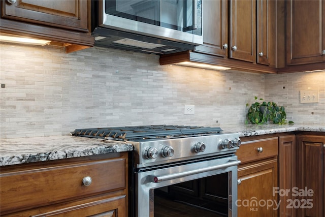 422 Deer Brush Ln, Waxhaw, NC 28173 - kitchen with appliances with stainless steel finishes, tasteful backsplash, and light stone countertops