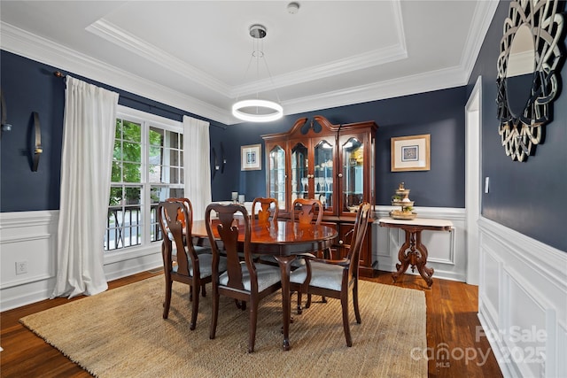 422 Deer Brush Ln, Waxhaw, NC 28173 - dining room featuring wood finished floors, a raised ceiling, a decorative wall, wainscoting, and ornamental molding