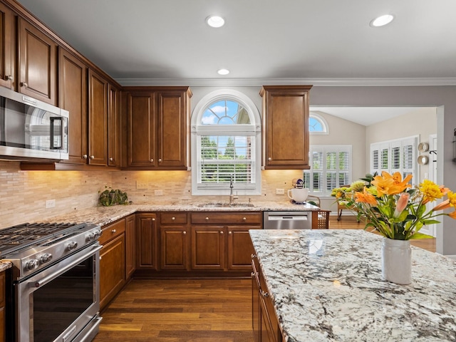 422 Deer Brush Ln, Waxhaw, NC 28173 - kitchen featuring stainless steel appliances, dark wood-type flooring, light stone counters, ornamental molding, and tasteful backsplash