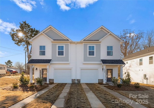 view of front facade with a garage, board and batten siding, driveway, and stone siding