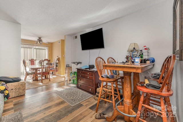 2026 Harvest Ln, Charlotte, NC 28210 - bar with a textured ceiling, ceiling fan, wood finished floors, and visible vents