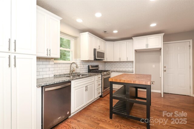 2011 Redwood Dr, Indian Trail, NC 28079 - kitchen featuring stainless steel appliances, white cabinetry, decorative backsplash, light stone countertops, and recessed lighting