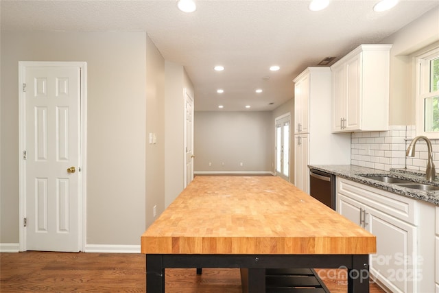 2011 Redwood Dr, Indian Trail, NC 28079 - kitchen with white cabinetry, stainless steel dishwasher, decorative backsplash, recessed lighting, and wood finished floors