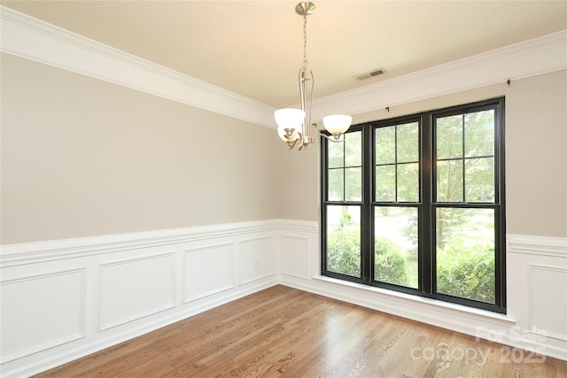 2011 Redwood Dr, Indian Trail, NC 28079 - unfurnished room featuring a chandelier, ornamental molding, a wainscoted wall, light wood-style floors, and a decorative wall