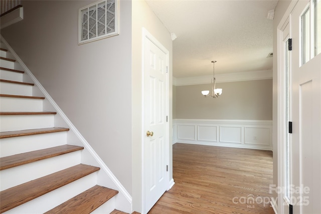 2011 Redwood Dr, Indian Trail, NC 28079 - stairs with wood finished floors, a chandelier, and crown molding