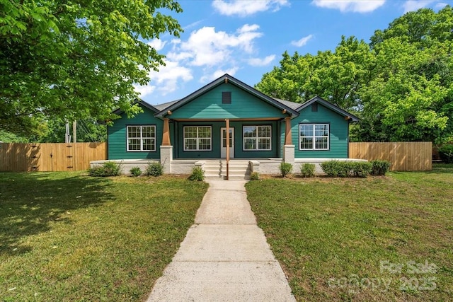 bungalow with a porch, fence, and a front yard