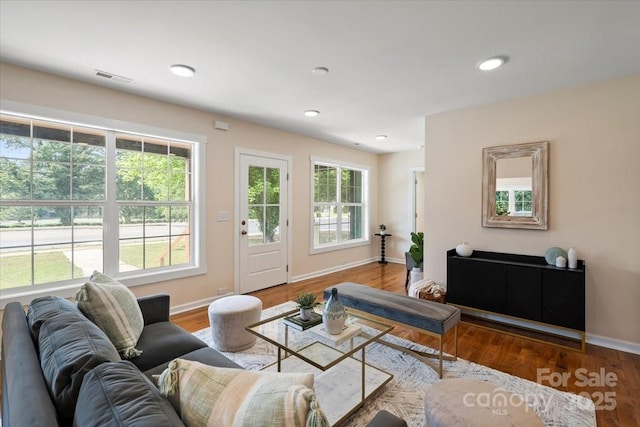 living area featuring visible vents, recessed lighting, baseboards, and wood finished floors