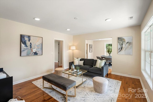 living area with visible vents, recessed lighting, baseboards, and wood finished floors