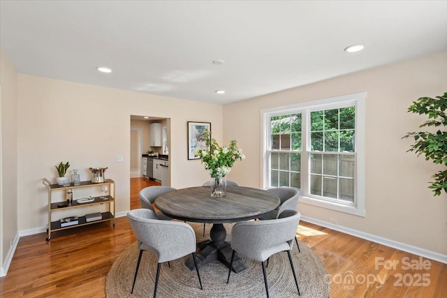 dining room with recessed lighting, baseboards, and light wood-style flooring