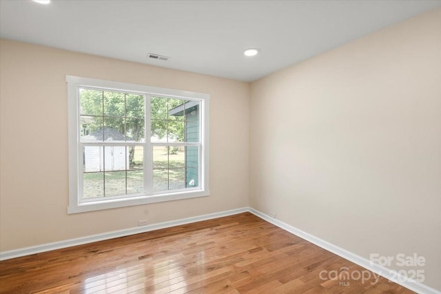 unfurnished room with recessed lighting, baseboards, visible vents, and light wood-style floors