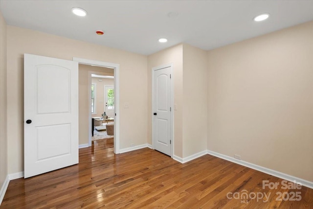 unfurnished bedroom with baseboards, recessed lighting, and wood finished floors