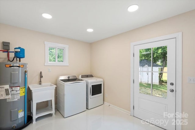washroom featuring laundry area, electric water heater, baseboards, recessed lighting, and washing machine and clothes dryer