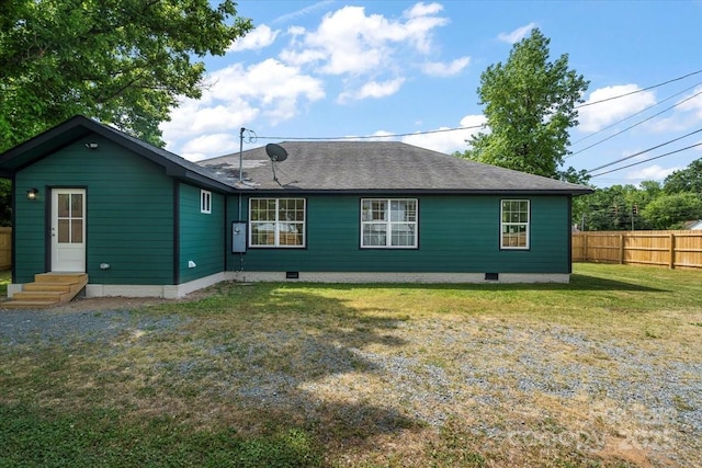 rear view of property with fence, roof with shingles, crawl space, entry steps, and a yard