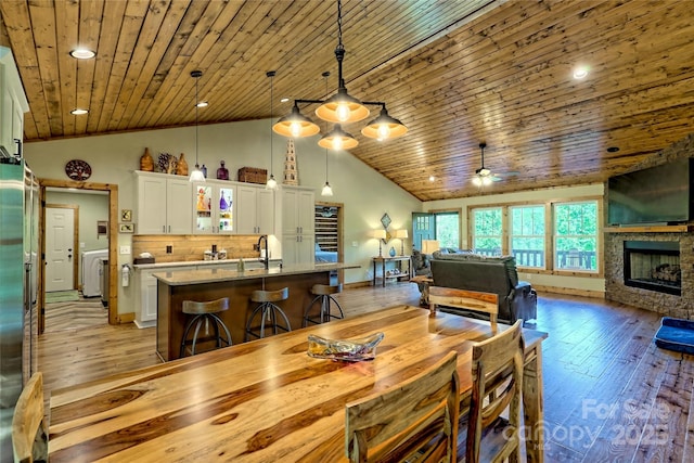 202 Wild Pear Ln Unit 3 & 7A, Franklin, NC 28734 - dining room with a ceiling fan, light wood finished floors, high vaulted ceiling, wooden ceiling, and a stone fireplace
