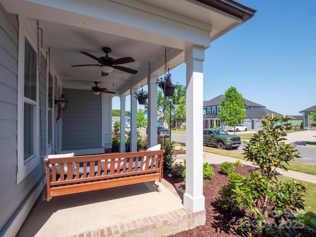 view of patio with covered porch, a baseboard radiator, a ceiling fan, and a residential view