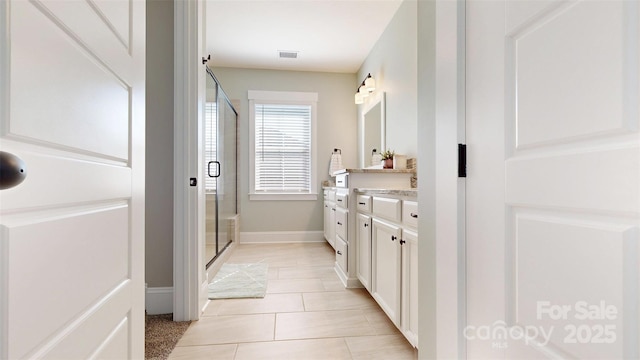bathroom with visible vents, a shower stall, vanity, baseboards, and tile patterned floors
