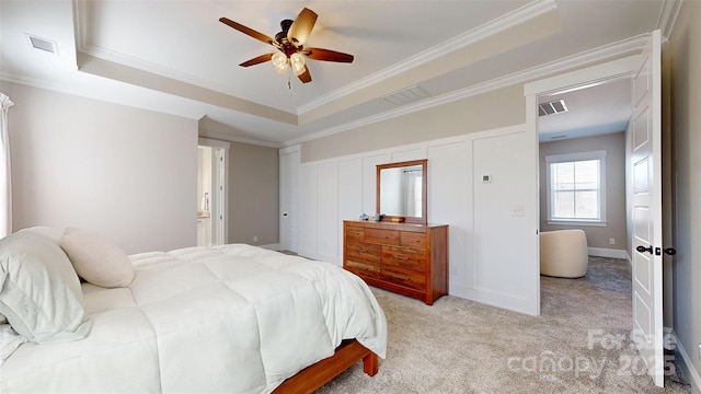 bedroom featuring a raised ceiling, ornamental molding, light colored carpet, and visible vents