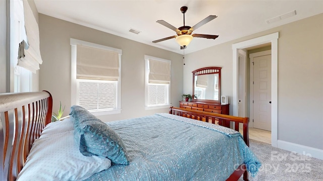 carpeted bedroom featuring baseboards, a ceiling fan, and visible vents