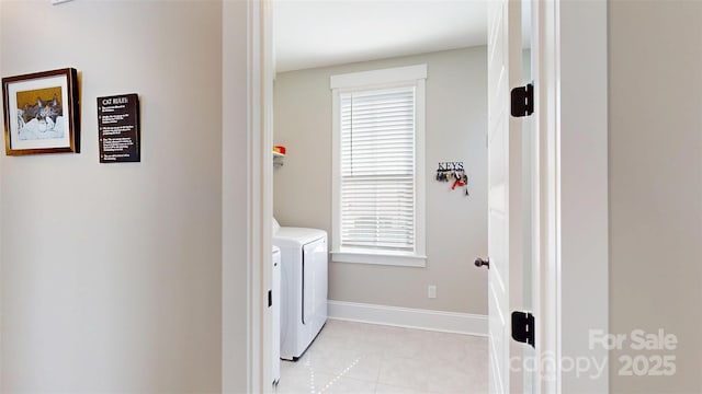 clothes washing area with laundry area, washer and clothes dryer, baseboards, and light tile patterned floors