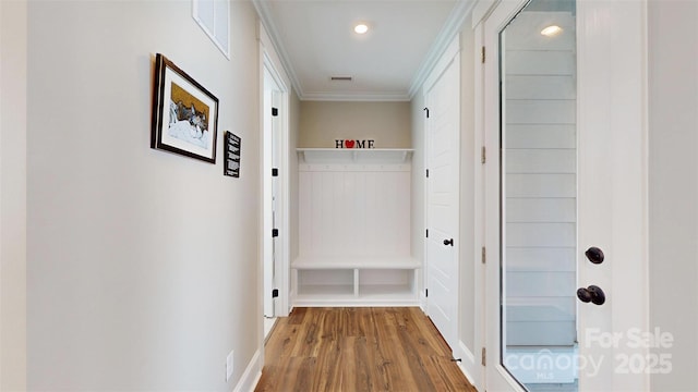 hall with visible vents, ornamental molding, wood finished floors, and recessed lighting