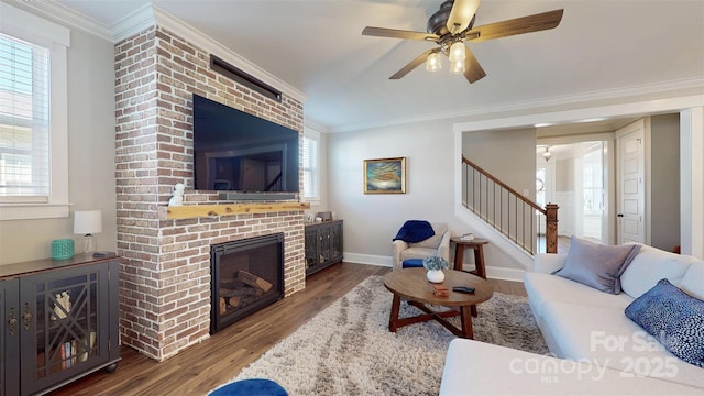 living room featuring ceiling fan, a fireplace, wood finished floors, stairway, and baseboards
