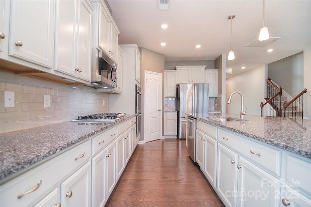 3073 Oliver Stanley Trl, Lancaster, SC 29720 - kitchen featuring decorative backsplash, white cabinetry, a sink, dark wood finished floors, and stainless steel appliances
