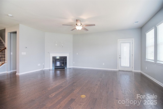 3073 Oliver Stanley Trl, Lancaster, SC 29720 - unfurnished living room featuring visible vents, ceiling fan, dark wood-style floors, stairway, and a fireplace with flush hearth