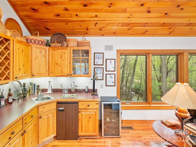 kitchen featuring beverage cooler, a sink, a wealth of natural light, and light wood finished floors