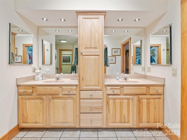 full bathroom with double vanity, a sink, and baseboards
