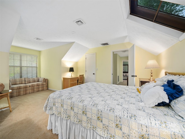 carpeted bedroom featuring lofted ceiling and visible vents