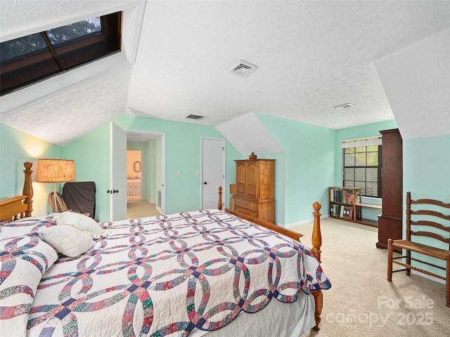bedroom featuring vaulted ceiling, carpet flooring, a textured ceiling, and visible vents