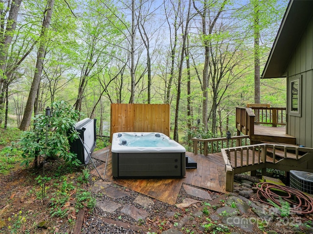 exterior space featuring a hot tub, a wooden deck, and central air condition unit