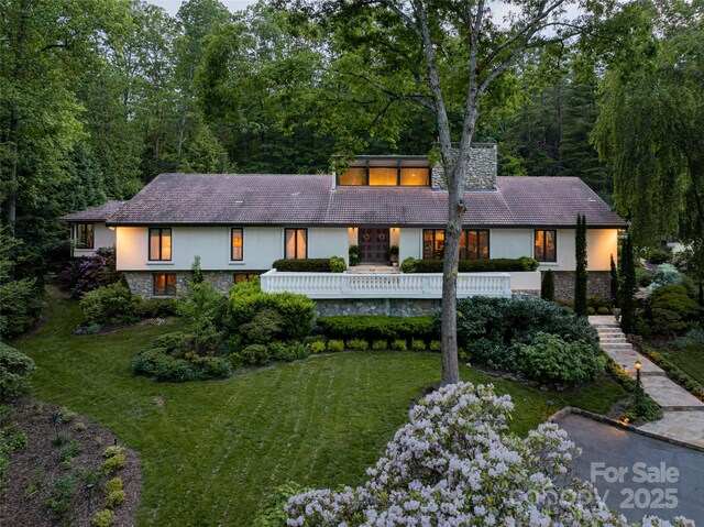 69 Forest Rd, Asheville, NC 28803 - view of front facade with stone siding, a front yard, a chimney, and stucco siding