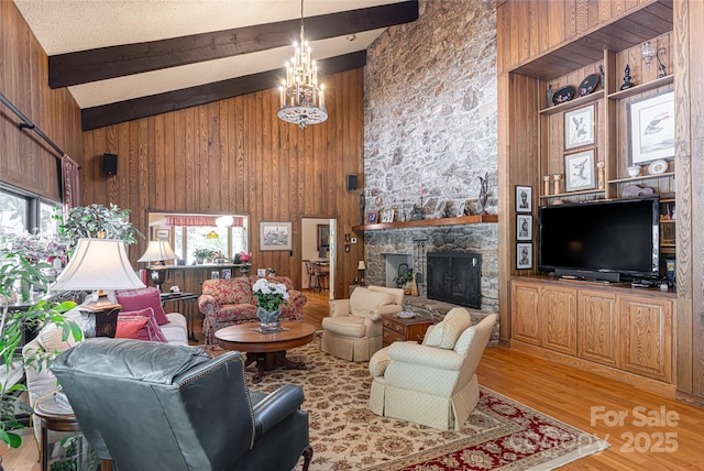 69 Forest Rd, Asheville, NC 28803 - living area with beamed ceiling, wood walls, light wood-type flooring, a stone fireplace, and high vaulted ceiling