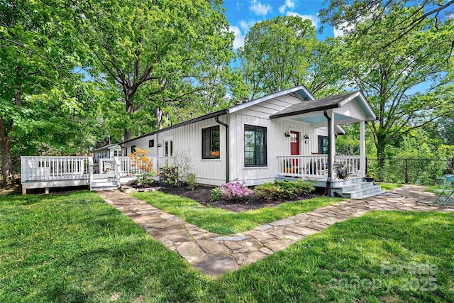 bungalow-style house featuring fence, covered porch, and a front yard