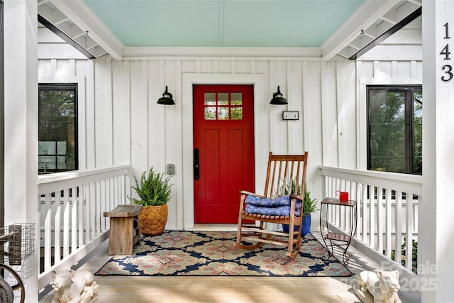 property entrance with board and batten siding and covered porch