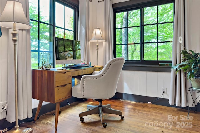 home office with a wealth of natural light and wood finished floors