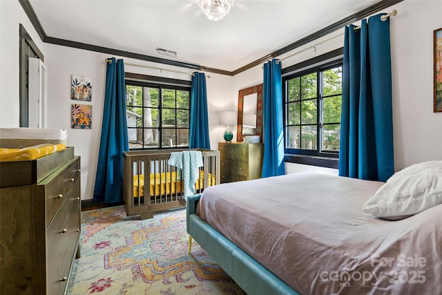 bedroom with visible vents, ornamental molding, and multiple windows